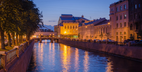 Night cityscape with river and bridge and ship in Saint-Petersburg.
