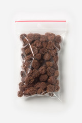 Plastic transparent zipper bag with home dry raspberries isolated on white, Vacuum package mockup with red clip. Concept.