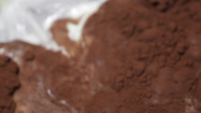 fresh milk dripping on cocoa powder and blending with it (closeup, FullHD) 