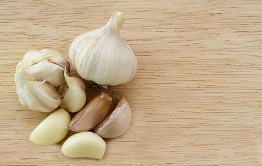 garlic and garlic cloves on wooden background.