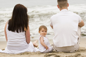 Young family having fun outdoors at the beach.