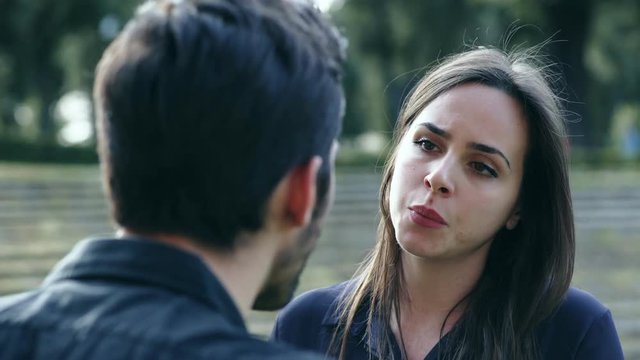 man and woman discuss about their relationship in a park