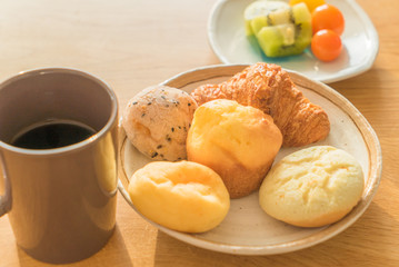 Bread and lots of fresh bread buns on a wooden table