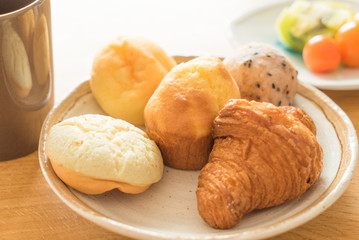 Bread and lots of fresh bread buns on a wooden table