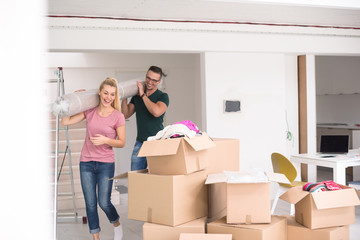 couple carrying a carpet moving in to new home