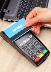 Hand of woman paying with contactless credit card with NFC technology, finance concept