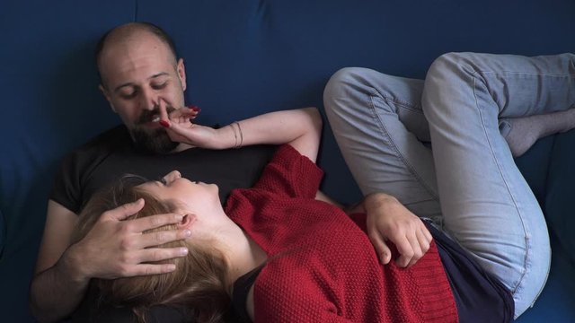 young couple on the couch chatting and laughs