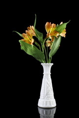 Fresh cut flowers in white vase and on black background