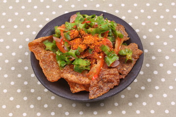 Spicy sour wing bean salad  with crispy pork served .