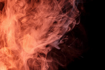 Abstract smoke Weipa. Personal vaporizers fragrant steam. The concept of alternative non-nicotine smoking. Orange smoke on a black background. E-cigarette. Evaporator. Taking Close-up. Vaping.