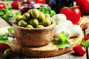 Green olives, cheese, tomatoes and wine, still life, selective focus