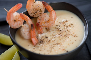 Cream-soup with potato and shrimps, selective focus, close-up