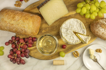 White wine, cheese, bread and grapes at tasting