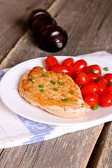 Steak chicken breast with cherry tomatoes on a white plate