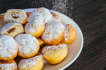 heap of marmalade filled bismarck donuts on white plate