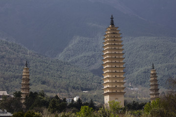 Three traditional chinese towers pagodas with mountains behind