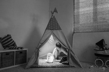 Boy playing in the teepee