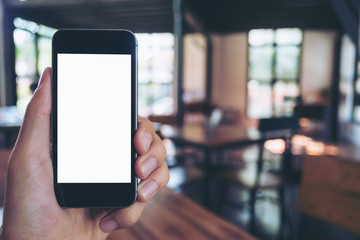 Mockup image of hand holding black mobile phone with blank white screen in cafe