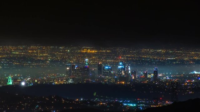 Timelapse of Los Angeles Skyline at night in Storm Clouds -Tilt Down-