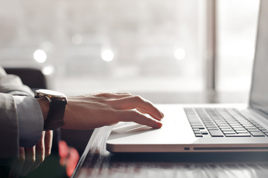 hand of a businessman on the touchpad of the laptop