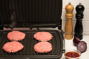 the table preparing minced meat on the grill