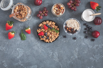 Healthy breakfast with muesli, fruits, berries, nuts on grunge background. Flat lay, top view