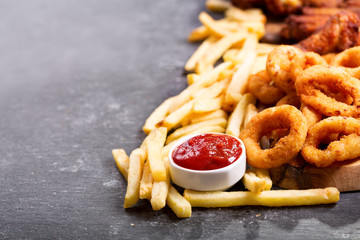fast food meals : onion rings, french fries and fried chicken
