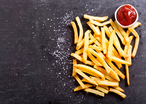 French fries with ketchup on dark table