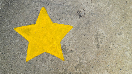 Yellow painting star on concrete texture background