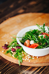 Healthy Salad with arugula, pine nuts, cranberries, tomatoes, and feta. Copy space