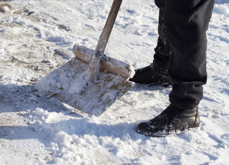 Worker cleans snow shovel