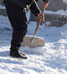 Worker cleans snow shovel