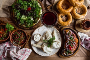 A lot of food on the wooden table. Georgian cuisine. Top view. Flat lay . Khinkali and Georgian...