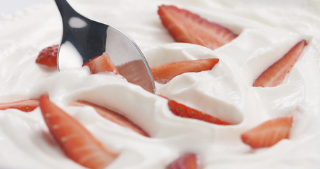 fresh sliced straberries in cream background with spoon