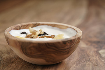 homemade yogurt with muesli in wood bowl on wooden table