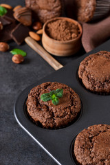 Chocolate muffins, brownies with nuts and chocolate on a black background