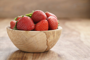 fresh strawberries in bowl on wood table