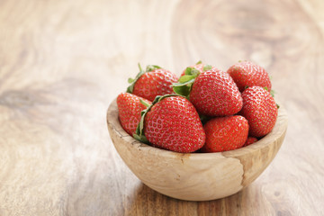 fresh strawberries in bowl on wood table