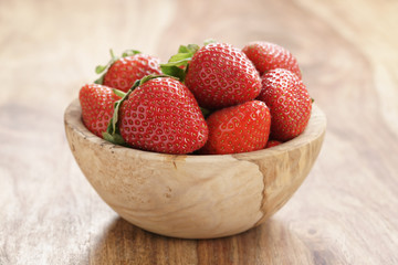 fresh strawberries in bowl on wood table