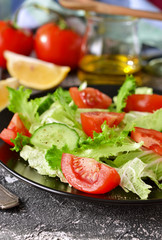 Vegetable salad with cucumber, tomatoes and olive oil on a concrete background