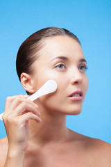 Jeune femme utilisant spatule de maquillage