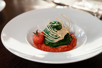 Stuffed spinach leaves with tomato sauce and cabbage