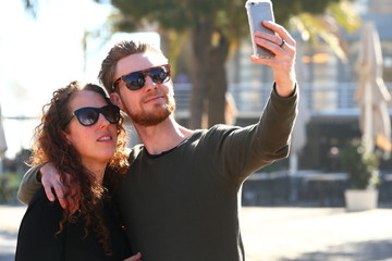 selfie/ young couple taking a picture of themselves by means of a mobile phone