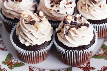 Chocolate cupcake with mousse cream icing on grunge white wooden background copy space