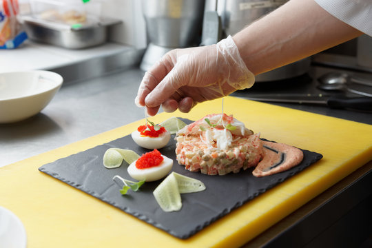 Chef is decorating crab salad in commercial kitchen