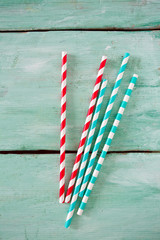 striped paper straws on turquoise wooden background