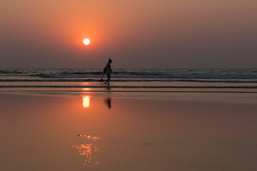 the person against the background of a sunset and the ocean