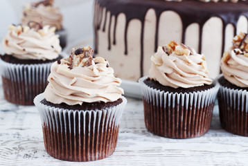 Chocolate cupcake with mousse cream icing on grunge white wooden background copy space
