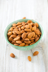 almonds in a bowl on wooden surface