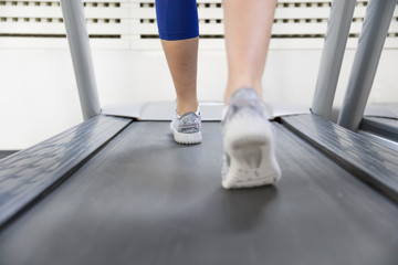 Fototapeta premium Fitness girl running on treadmill